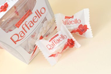 KHARKOV, UKRAINE - 26 Mart 2020: Bej arkaplanda Raffaello şekerlemeleri. Raffaello, İtalyan imalatçı Ferrero 'nun 1990 yılında pazara getirdiği küresel bir hindistan cevizi badem şekerlemesi.