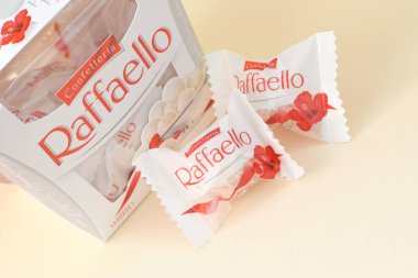 KHARKOV, UKRAINE - MARCH 26, 2020: Raffaello candies on beige background. Raffaello is a spherical coconut almond confection that Italian manufacturer Ferrero brought to the market in 1990 clipart