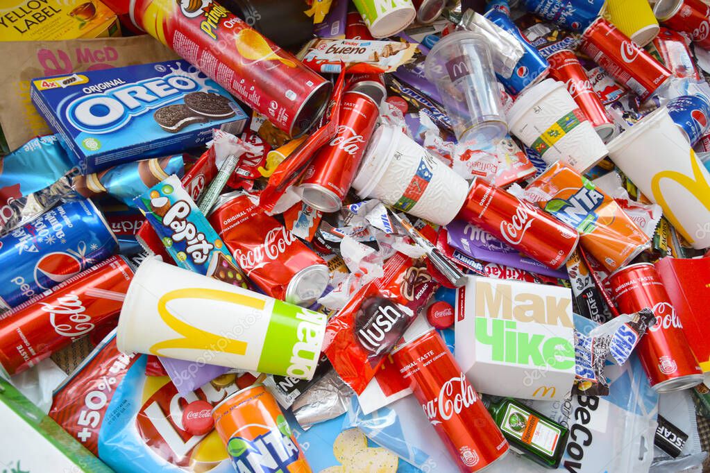 KHARKOV, UKRAINE - APRIL 8, 2020: Many wrappings and cans from used products by famous worldwide brands. Pattern of trash of various colors and materials