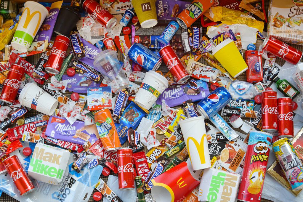 KHARKOV, UKRAINE - APRIL 8, 2020: Many wrappings and cans from used products by famous worldwide brands. Pattern of trash of various colors and materials