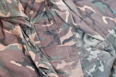 Avcılık ya da balıkçılık tasarımı projeleri için arka plan dokusu olarak kamuflaj yapın. Avcıların arka tarafı buruşuk kumaşlarda birçok pileli kamuflaj ceketi