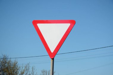 Beyaz bir üçgen şeklinde trafik işareti. Yol simgesi ver
