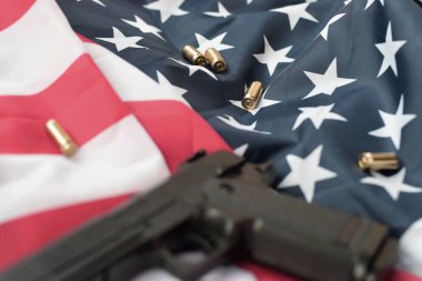 9mm 'lik mermiler ve tabancalar katlanmış ABD bayrağında yatıyor. Kendini koruma gereçleri ya da özel servis kiti