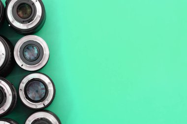 Parlak turkuaz arka planda birkaç fotoğraf lensi var. Metin için boşluk