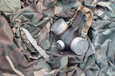 Takipçi askerler sovyet gaz maskesi yeşil haki rengi kamuflaj ceketli bıçakla yatar. Kıyamet sonrası hayatta kalan ögeler kiti