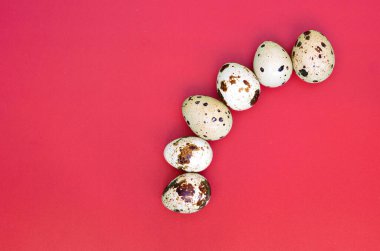 Açık kırmızı bir yüzey üzerinde bıldırcın yumurtaları, üst görünüm, metin için boş yer, tarif