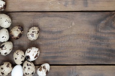 Koyu kahverengi ahşap yüzeyde bıldırcın yumurtaları, üst görüş, metin için boş yer, tarif