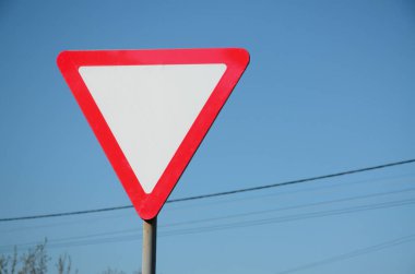 Beyaz bir üçgen şeklinde trafik işareti. Yol simgesi ver