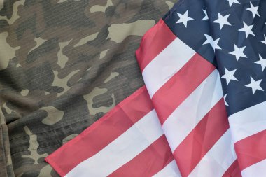 Amerika Birleşik Devletleri bayrağı ve katlanmış askeri üniforma ceketi. Amerikan vatanseverlik bayramları için askeri semboller kavramsal arka plan pankartı