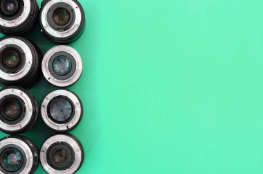 Parlak turkuaz arka planda birkaç fotoğraf lensi var. Metin için boşluk