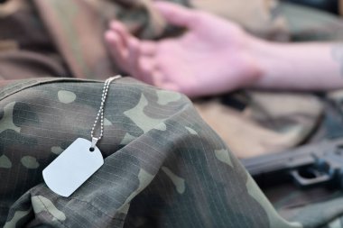 Ölü askerin boş ordu simgesi kamuflaj giysilerinde yatıyor. Rus askeri konseptinde askerlik sırasında intihar
