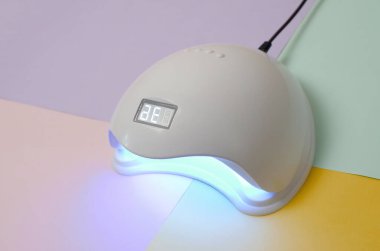 Jel metoduyla iyileştirme işlemi için UV LED lambası çok renkli masalarda bulunur. Kızılötesi indüksiyon tırnakların çabuk kurumasına ve iyileşmesine yardımcı olur.