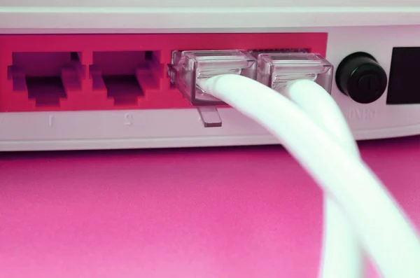 The Internet cable plugs are connected to the Internet router, which lies on a bright pink background. Items required for Internet connection