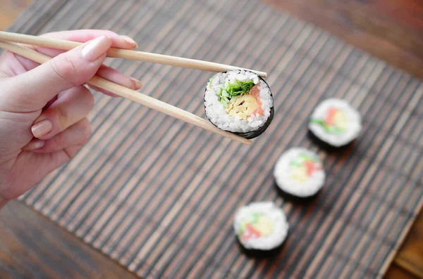 Hand Med Ätpinnar Håller Sushi Rulle Bambu Halm Serwing Matta — Stockfoto