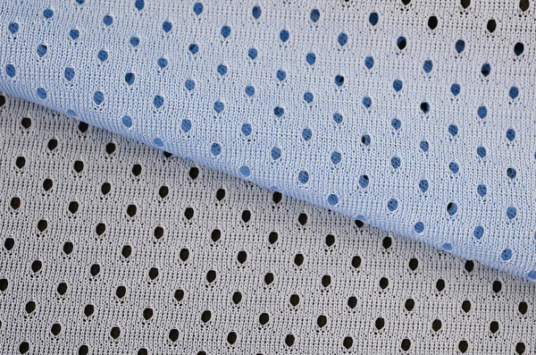 Blue mesh sport wear fabric textile pattern background. Blue color football jersey clothing fabric texture sports wear. Breathable porous poriferous material air ventilation with small holes