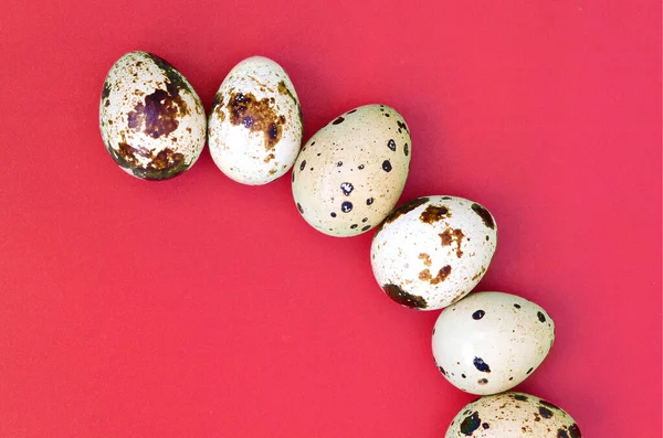 Quail eggs on a light red surface, top view, empty place for text, recipe