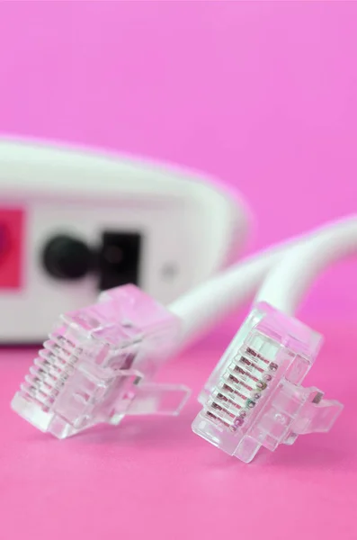 Internet router and Internet cable plugs lie on a bright pink background. Items required for Internet connection
