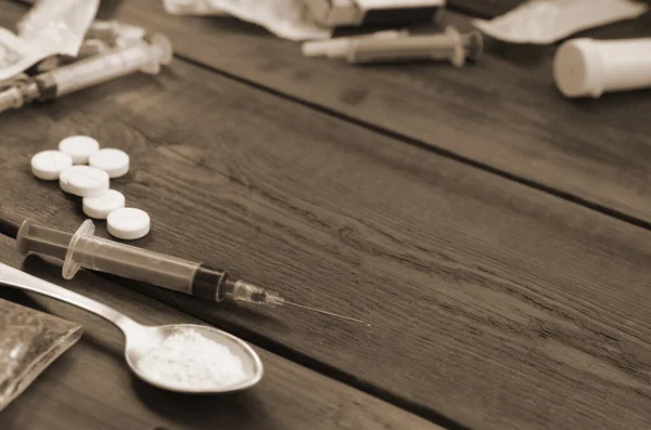 许多制造毒品的麻醉物质和设备都放在一张旧的木制桌子上 毒贩的事海洛因和甲基苯丙胺处于原始状态 吸毒成瘾概念 — 图库照片