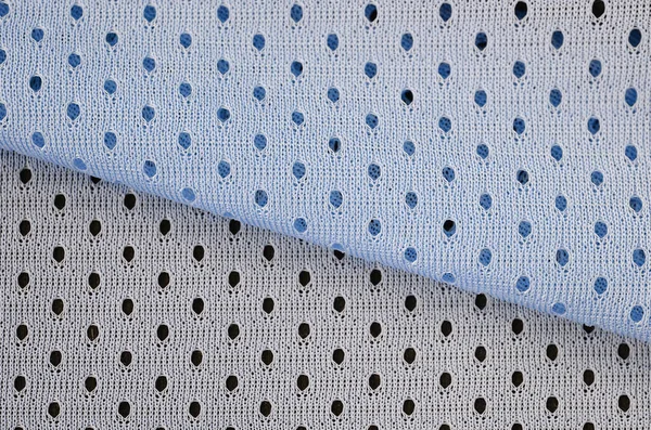 Blue mesh sport wear fabric textile pattern background. Blue color football jersey clothing fabric texture sports wear. Breathable porous poriferous material air ventilation with small holes