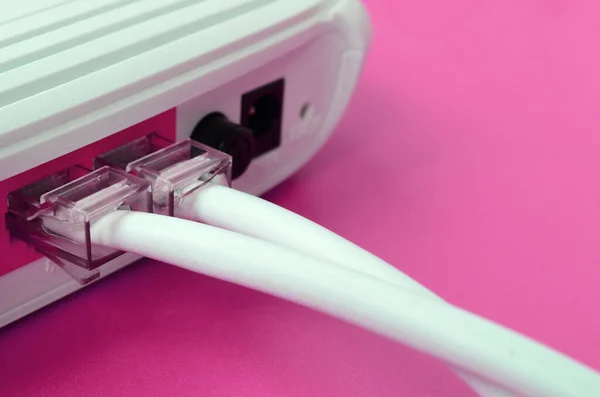 The Internet cable plugs are connected to the Internet router, which lies on a bright pink background. Items required for Internet connection