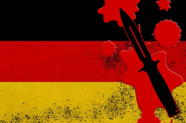 Germany flag and black tactical knife in red blood. Concept for terror attack or military operations with lethal outcome. Dangerous melee weapon usage