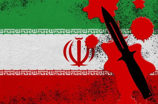 Iran flag and black tactical knife in red blood. Concept for terror attack or military operations with lethal outcome. Dangerous melee weapon usage