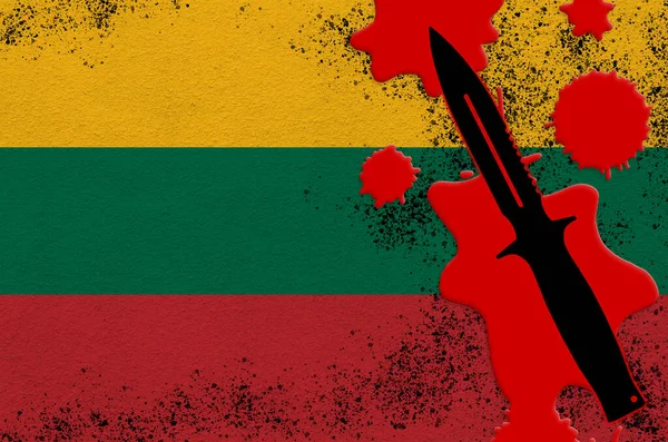 Lithuania flag and black tactical knife in red blood. Concept for terror attack or military operations with lethal outcome. Dangerous melee weapon usage