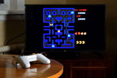 KHARKOV, UKRAINE - NOVEMBER 12, 2020: Dendy video oyun denetleyici ve Pac Man oyunu büyük ekranda