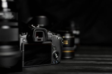 KHARKOV, UKRAINE - 23 Kasım 2020: Canon EOS R fotoğraf makinesi ve siyah masa üzerinde Canon lensler. Canon EOS R, Canon tarafından 2018 yılında fırlatılan 30mp tam kare aynasız değiştirilebilir lens kamerasıdır.