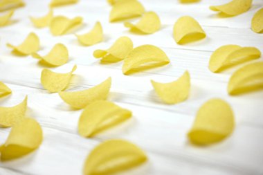 KHARKOV, UKRAINE - 23 Kasım 2020: Birçok portakallı Pringles patates cipsi beyaz ahşap masada. Pringles, Kellog Şirketi 'ne ait bir patates cipsi markası.