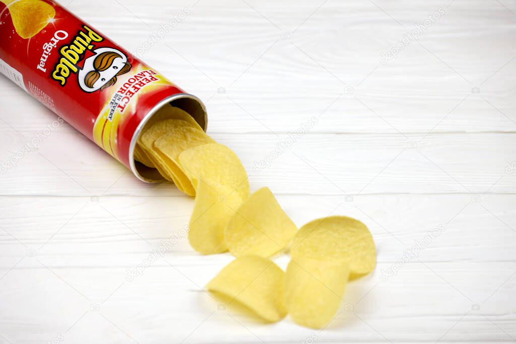 KHARKOV, UKRAINE - NOVEMBER 23, 2020: Pringles original flavour. Cardboard tube can with Pringles potato chips on white table. Pringles is a brand of potato snack chips owned by the Kellogg Company