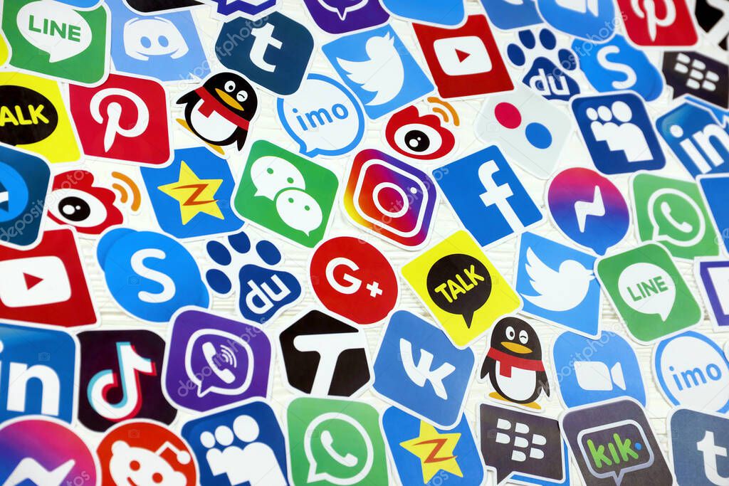 KHARKOV, UKRAINE - DECEMBER 26, 2020: Paper logos of most popular social networks and mobile messengers on wooden background. Facebook instagram youtube twitter tiktok twitch reddit and others