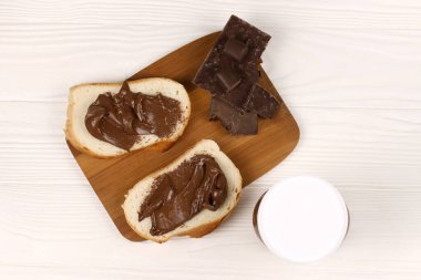 KHARKOV, UKRAINE - 27 Aralık 2020: Nutella cam kutu ve taze pişmiş ekmek üzerine yayılmış. Nutella, İtalyan Ferrero firması tarafından 1964 yılında üretilmiştir.