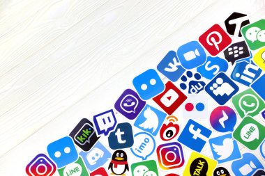 KHARKOV, UKRAINE - 26 Aralık 2020: En popüler sosyal ağların kağıt logoları ve ahşap arka planda mobil kuryeler. Facebook Instagram youtube twitter tiktok seğirme reddit ve diğerleri