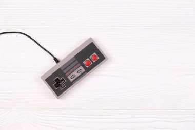 KHARKOV, UKRAINE - 27 Aralık 2020: 8-bit video oyunu konsolu için eski oyun alanı nintendo eğlence sistemi ve beyaz ahşap masa üzerinde nes mini. Eski moda oyun.