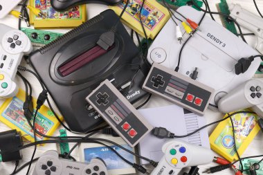 KHARKOV, UKRAINE - 27 Aralık 2020: Eski 8-bit video oyun konsolları ve joystick ve kartuşlar gibi birçok oyun aksesuarı yığını. Eski moda oyun.