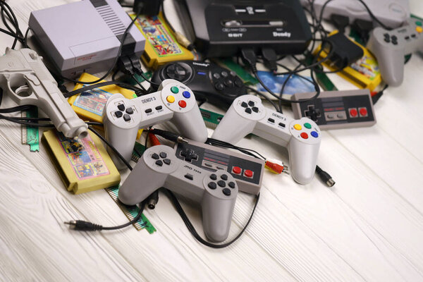 Харьков, Украина - 27 ДЕКАБРЯ 2020: Куча старых 8-битных игровых консолей и множество игровых аксессуаров, таких как джойстики и картриджи. Ретро-игры старой школы