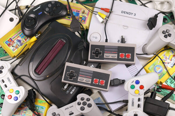 Харьков, Украина - 27 ДЕКАБРЯ 2020: Куча старых 8-битных игровых консолей и множество игровых аксессуаров, таких как джойстики и картриджи. Ретро-игры старой школы
