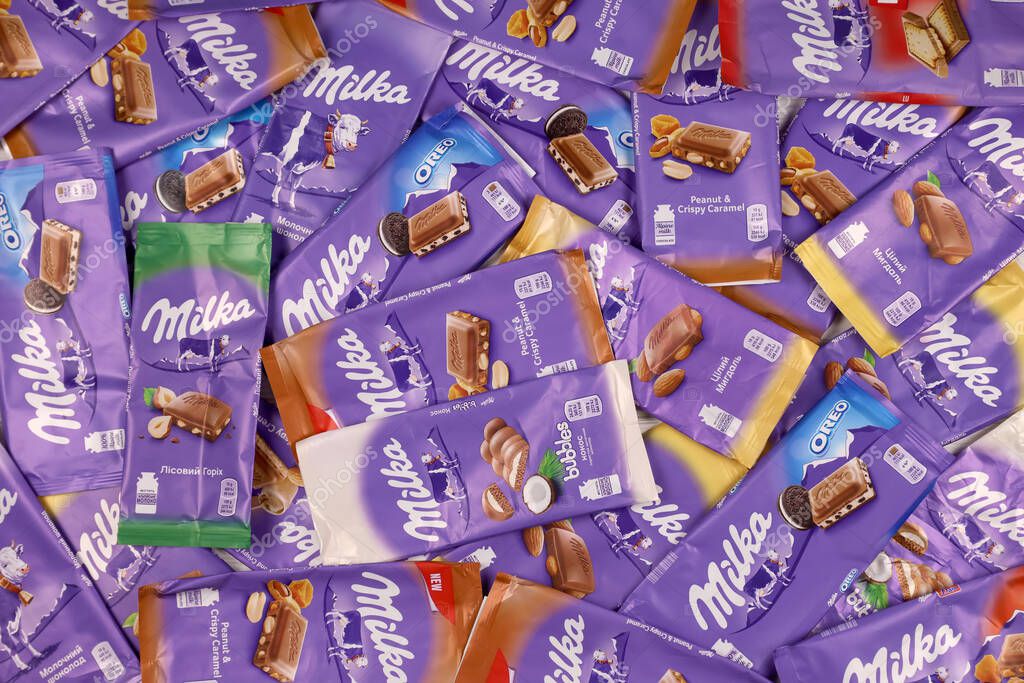 KHARKOV, UKRAINE - DECEMBER 8, 2020: Many wrappings of purple Milka chocolate. Milka is a Swiss brand of chocolate confection manufactured internationally by company Mondelez International