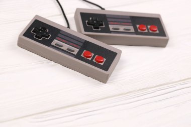 KHARKOV, UKRAINE - 27 Aralık 2020: 8-bit video oyun konsolları için iki eski oyun konsolu nintendo eğlence sistemi ve beyaz ahşap masa üzerinde nes mini. Eski moda oyun.