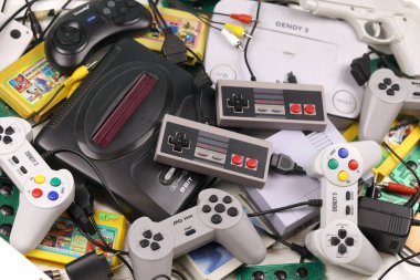 KHARKOV, UKRAINE - 27 Aralık 2020: Eski 8-bit video oyun konsolları ve joystick ve kartuşlar gibi birçok oyun aksesuarı yığını. Eski moda oyun.