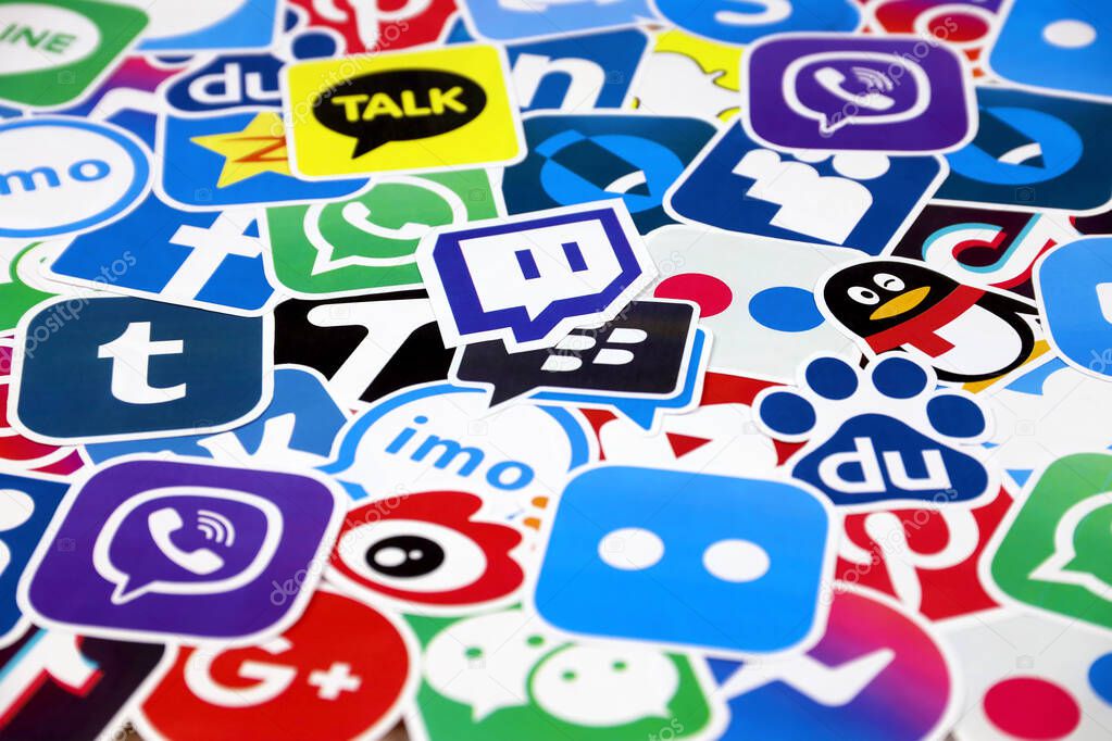 KHARKOV, UKRAINE - DECEMBER 26, 2020: Paper logos of most popular social networks and mobile messengers on wooden background. Facebook instagram youtube twitter tiktok twitch reddit and others
