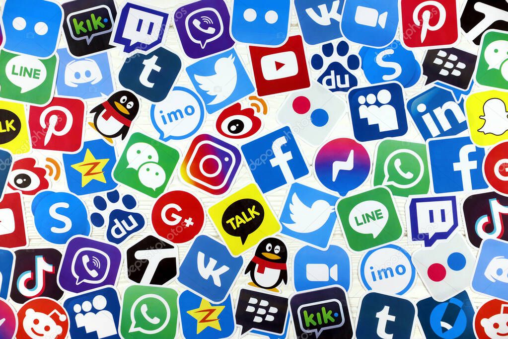KHARKOV, UKRAINE - DECEMBER 26, 2020: Paper logos of most popular social networks and mobile messengers on wooden background. Facebook instagram youtube twitter tiktok twitch reddit and others