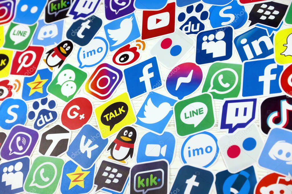 KHARKOV, UKRAINE - DECEMBER 26, 2020: Paper logos of most popular social networks and mobile messengers on wooden background. Facebook instagram youtube twitter tiktok twitch reddit and others