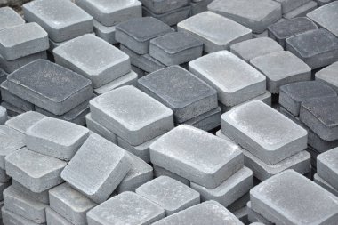 Açık havada uzanan gri ve koyu gri yol levhası yığını. Mozaik yakın plan Paving Levhaları için malzeme. Çakıl taşı üretim deposu