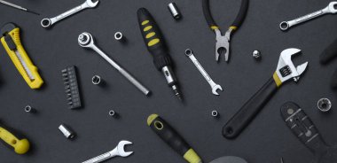 Siyah ahşap masada el işi alet çantası. Onarım ve inşaat işleri için birçok anahtar ve tornavida, sütun ve diğer aletler. Tamirci araçları ayarlandı