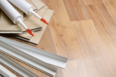 PVC tavan çalışması için malzeme seti. Yapıştırıcı şişeler ve plastik köşeli PVC paneller. Kapalı VPC kaplama kiti. İç yenileme çalışmaları veya inşaat malzemeleri