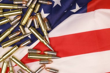 Birçok sarı 9mm ve 5.56 mm 'lik mermiler ve ABD bayrağında fişekler. ABD topraklarında silah kaçakçılığı veya özel harekat kavramı