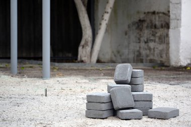 Dışarıdaki yığının içinde gri kaldırım levhaları var. Mozaik 'ten Paving Levhaları için malzeme. Çakıl taşı kurulum süreci