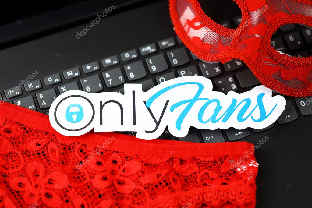KHARKOV, UKRAINE - FEBRUARY 14, 2021: Onlyfans paper logo and red lingerie on black laptop keyboard. OnlyFans is content subscription service based in London, United Kingdom